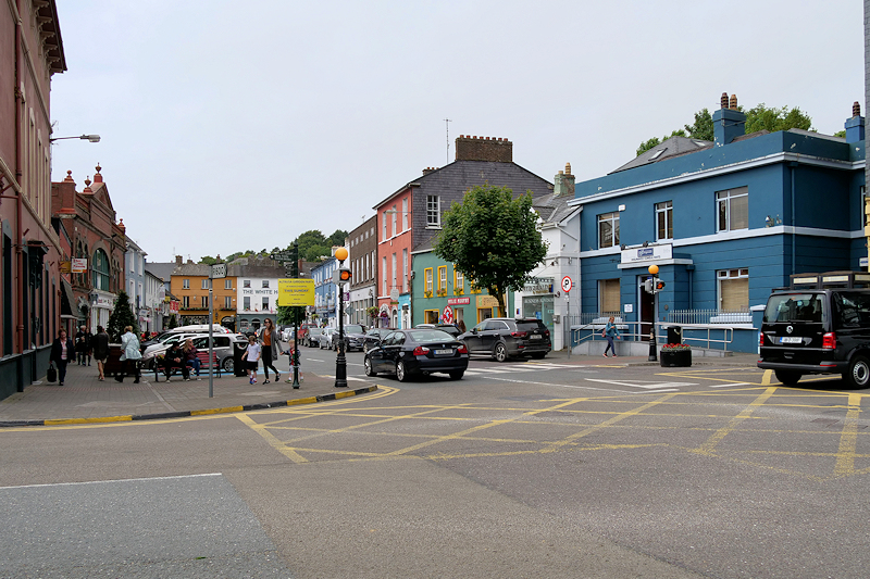 An image pointing up Pearse street in Kinsale towards the white house. The image has bolands on the left and the zebra crossing in the middle.